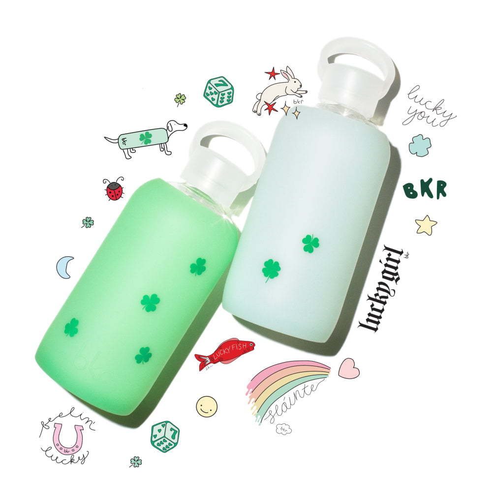 Reusable glass and silicone water bottles in sheer ethereal spring green and sheer mint sea glass with mini green shamrocks print.