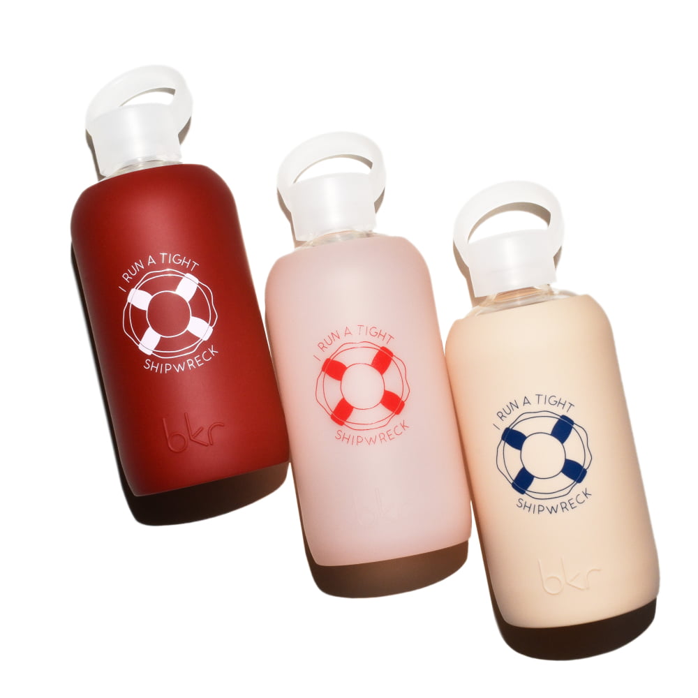 bkr glass and silicone reusable water bottles in opaque Venice brick red with pink "I run a tight shipwreck" print, sheer whispering peach with red "I run a tight shipwreck" print, and opaque linen with blue "I run a tight shipwreck" print.