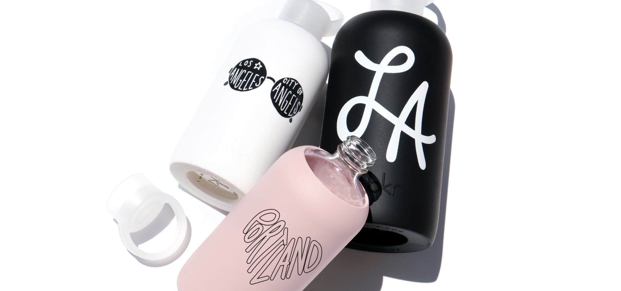 bkr glass and silicone water bottles in different colors with different location prints