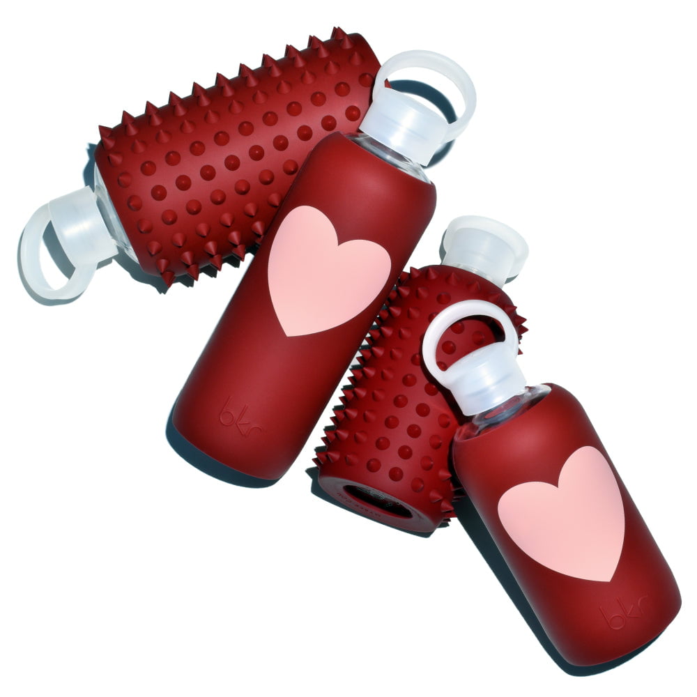 Reusable glass and silicone water bottles in spiked Venice brick red and Venice brick red with light Paris-ish peach heart.