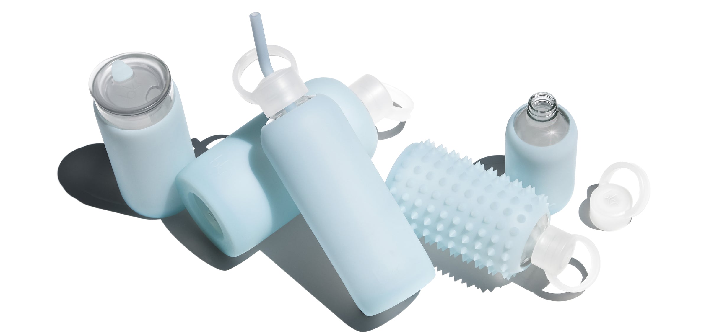 Reusable glass and silicone water bottles in sheer glacial milk blue.