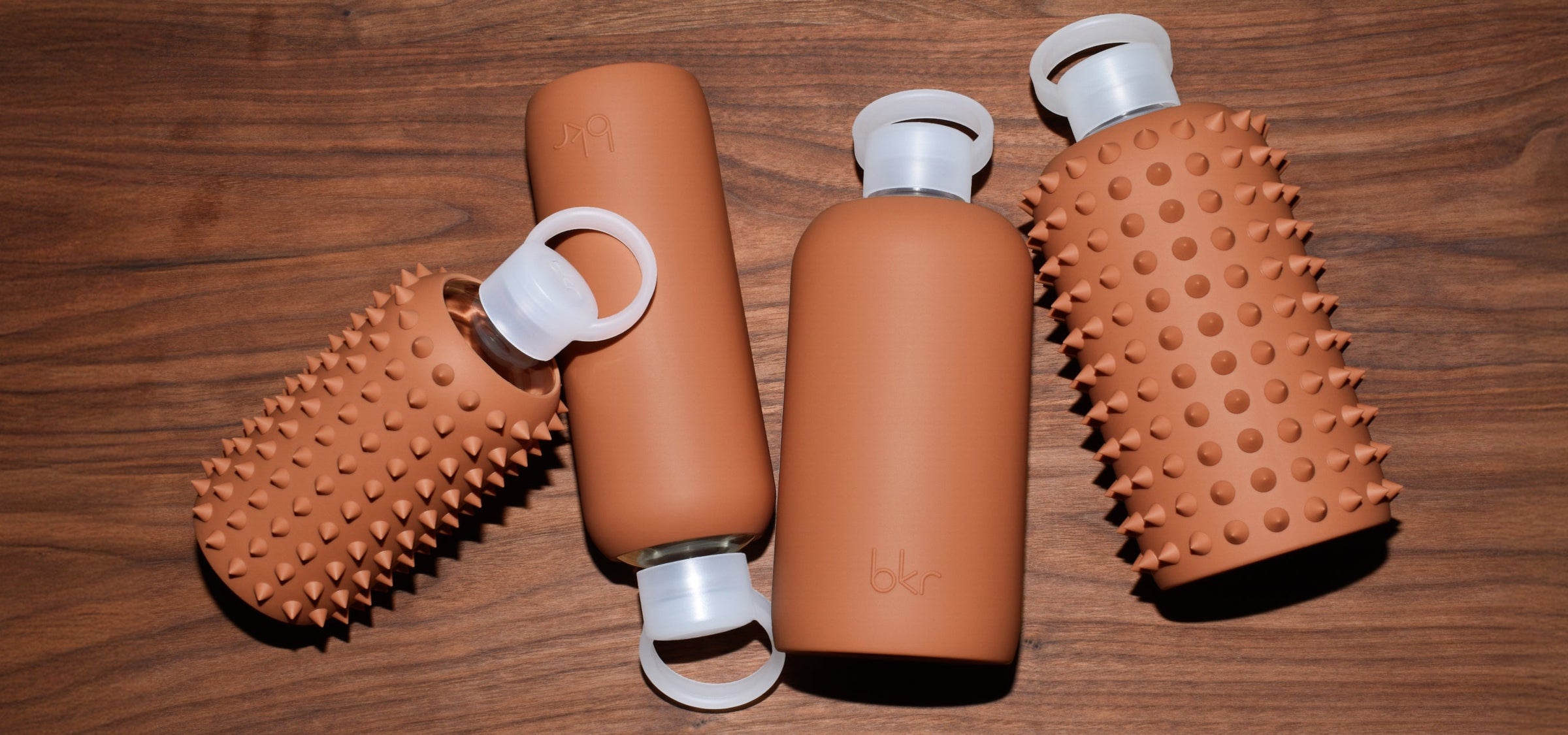bkr glass and silicone reusable water bottles in opaque earthy ginger terracotta.