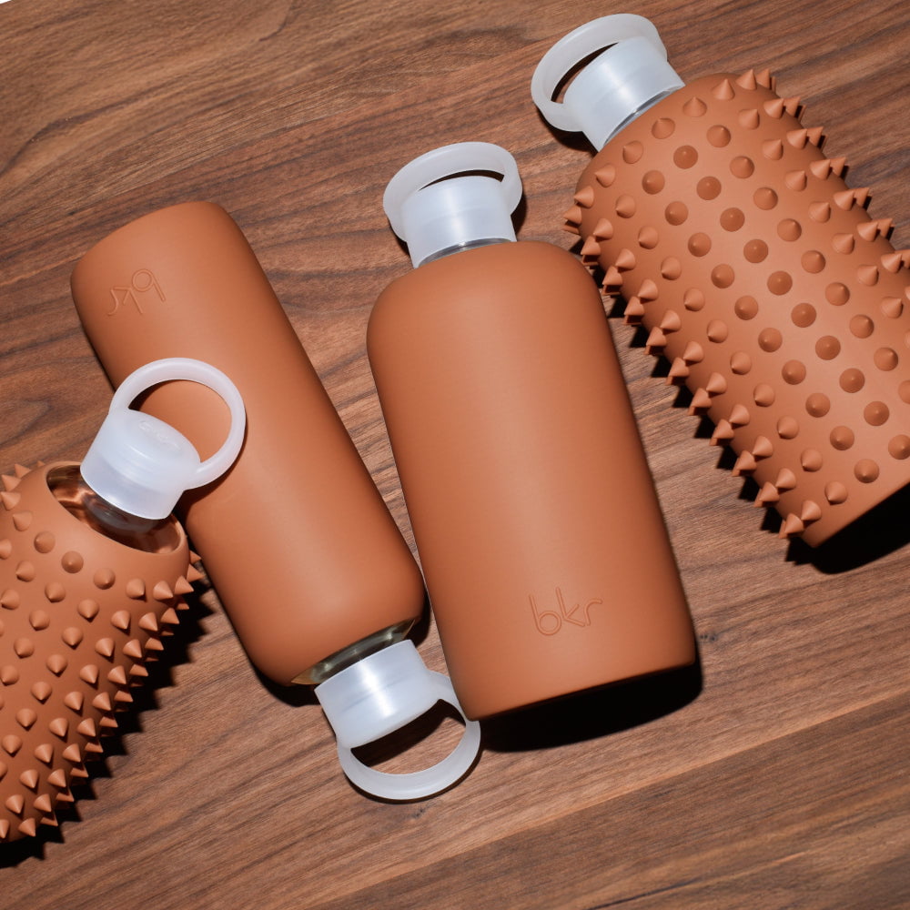 bkr glass and silicone reusable water bottles in opaque earthy ginger terracotta.