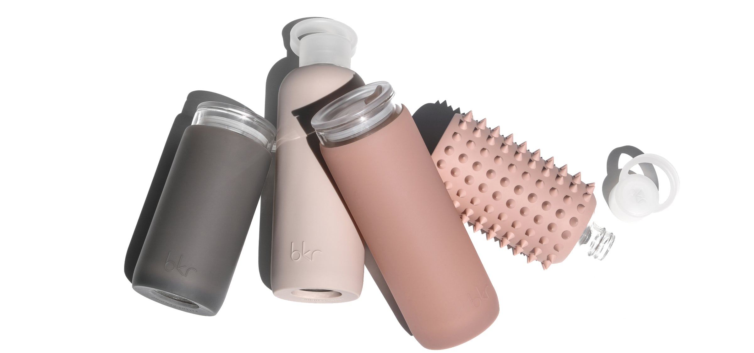 Reusable glass and silicone water bottles and insulated tumblers in natural neutrals.