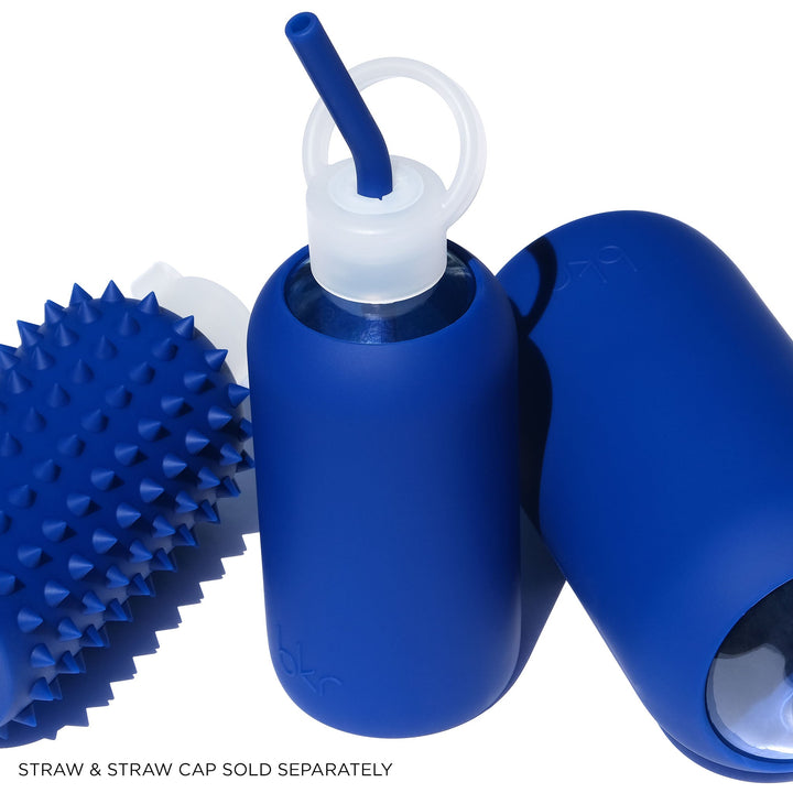 Three bright blue bkr glass and silicone reusable water bottles with various caps and sleeve textures. Color name is Beau.